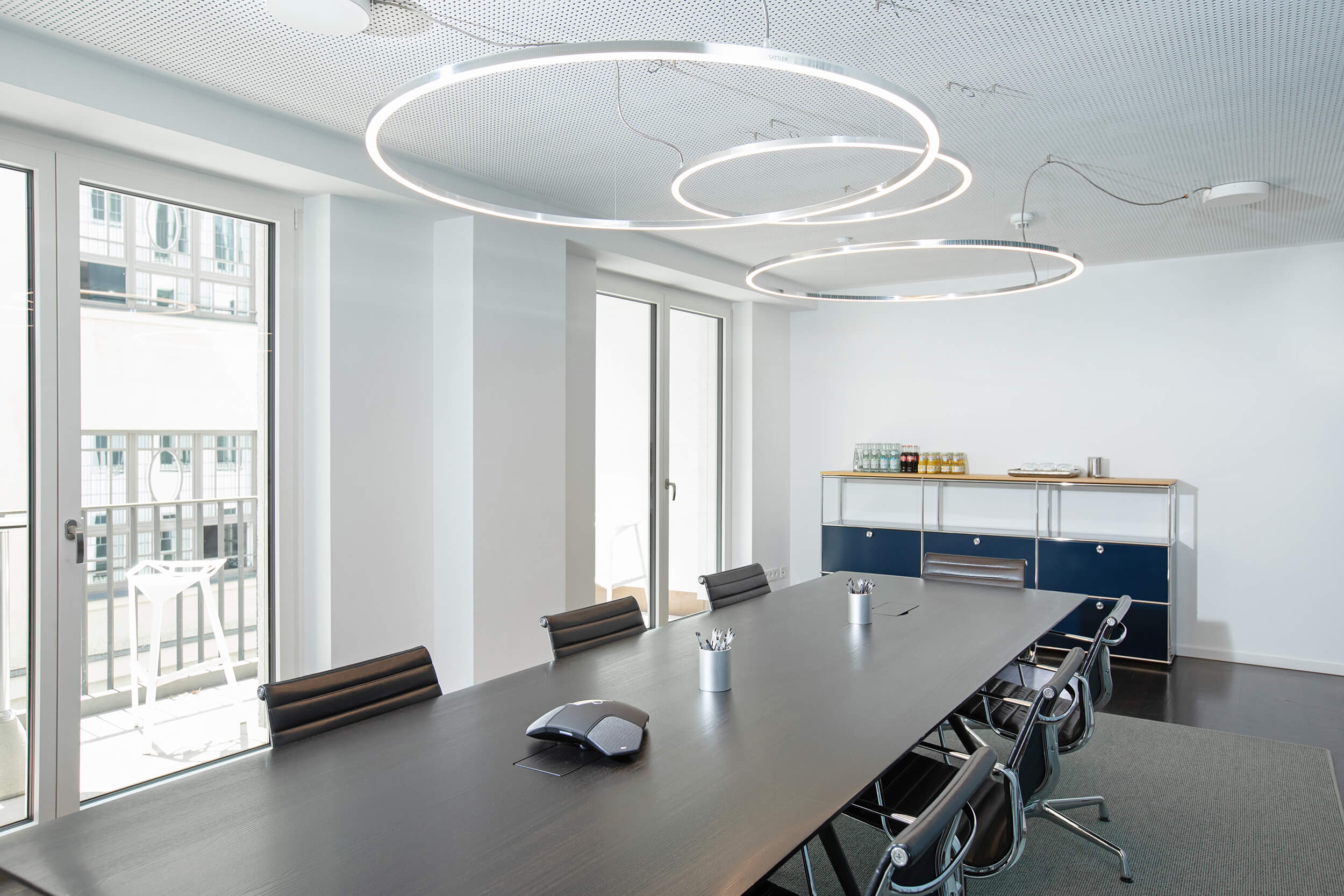 Heller Besprechungsraum mit großer Fensterfront und bereitgestellten Getränken.