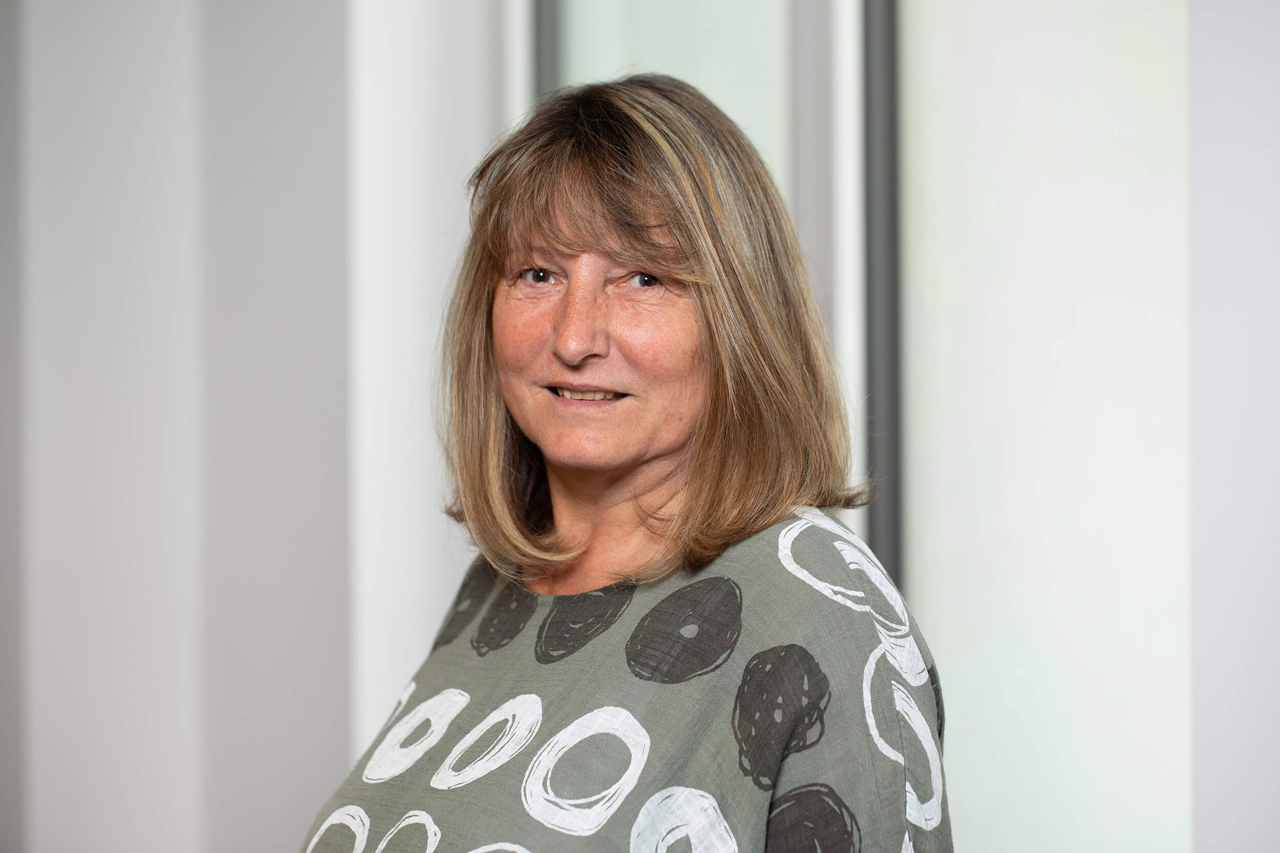 Portraitfoto von Petra Stangassinger vor neutralem Hintergrund.