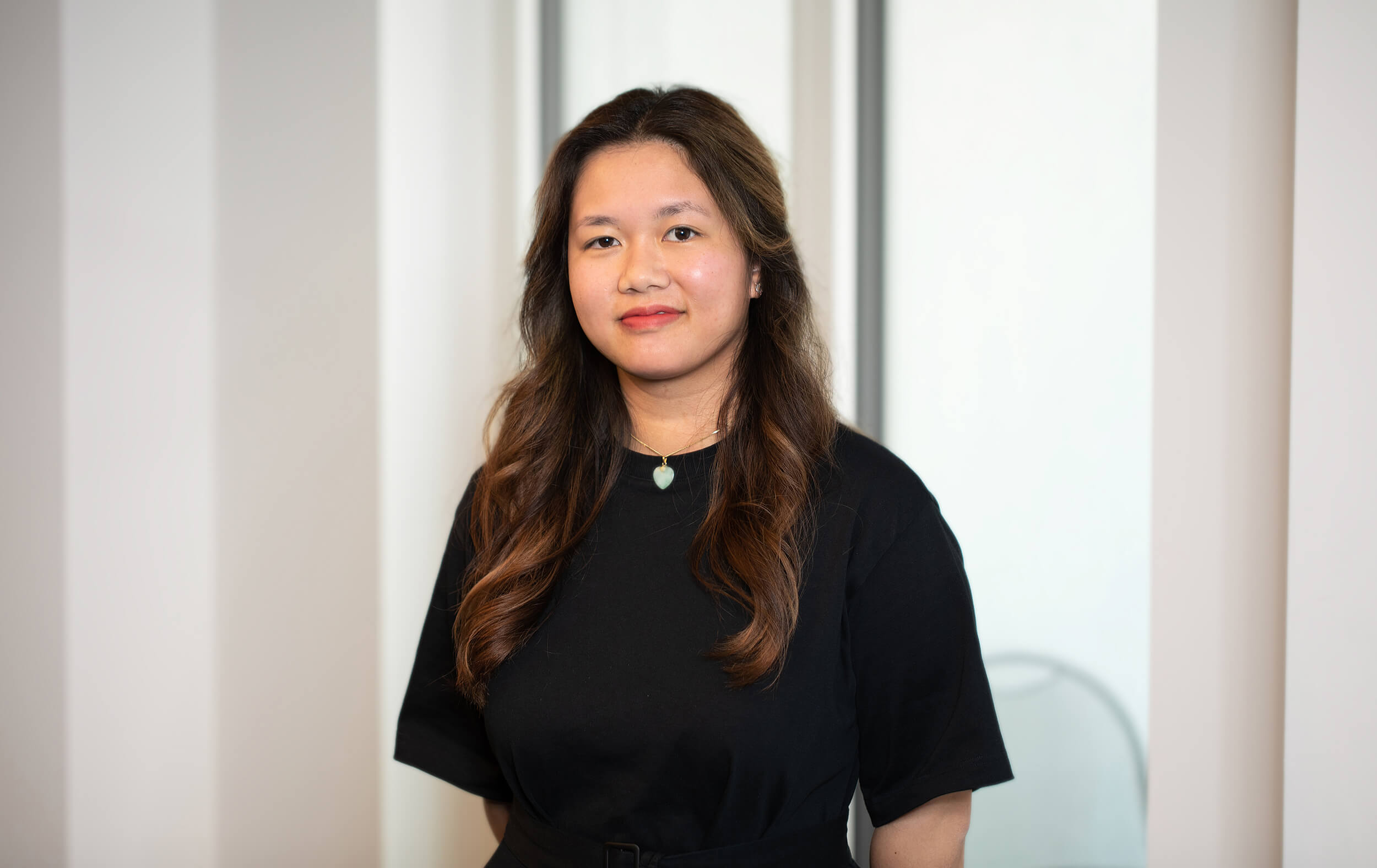 Portraitfoto von Thao Tran vor neutralem Hintergrund.