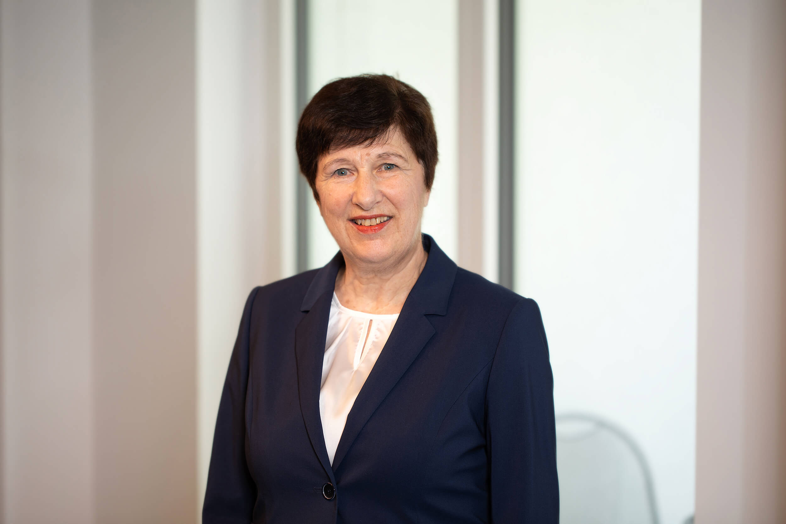 Portraitfoto von Wilma Mark vor neutralem Hintergrund.
