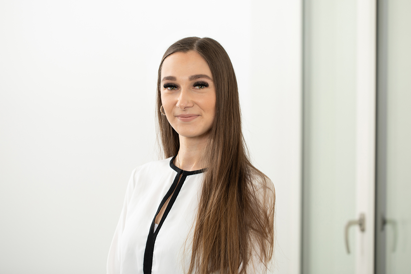 Portraitfoto von Laura Still vor neutralem Hintergrund.